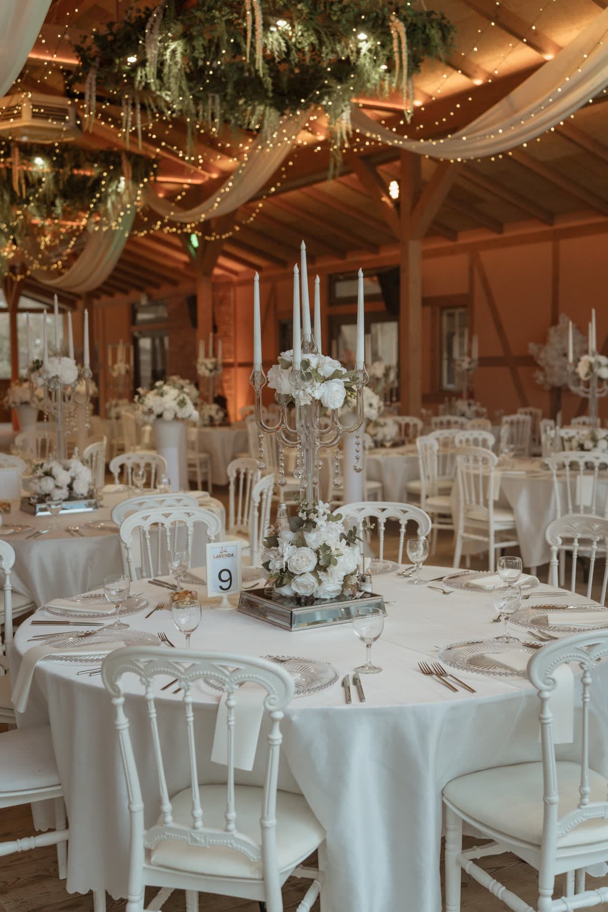 Runde Hochzeitstafel mit Kristall-Kerzenleuchter und weißen Blumen bei Lavenda am See
